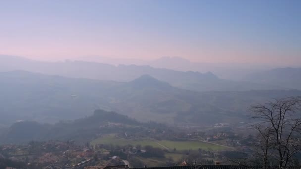 Ciudad rodeada de colinas y cubierta de niebla matutina — Vídeos de Stock