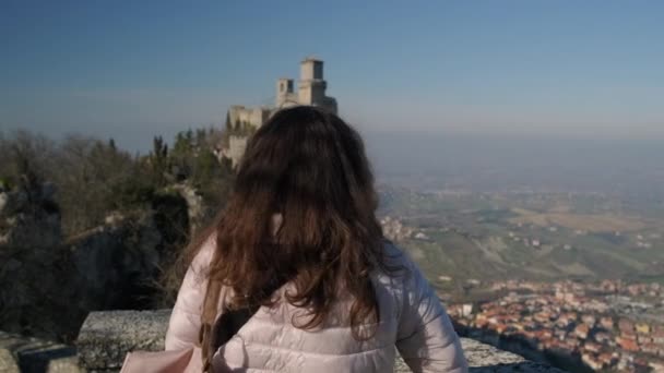 Long haired brunette admires Fortress of Guaita tower — Stock Video