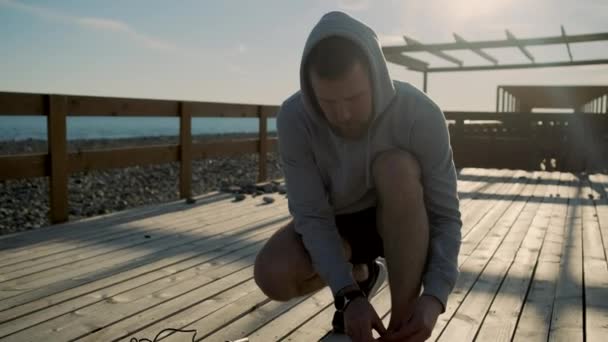 Mann bindet Schnürsenkel vor dem Training — Stockvideo