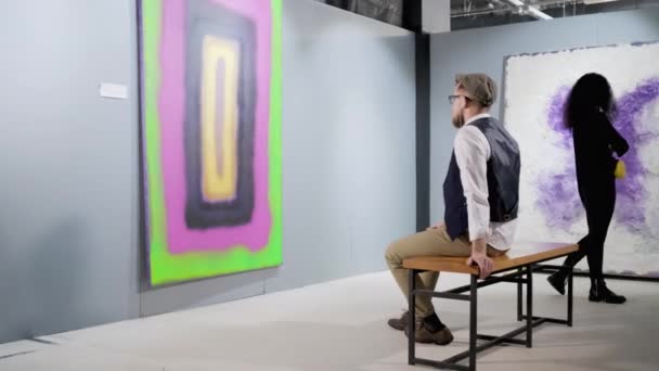 Visitante da galeria de arte com guia de áudio — Vídeo de Stock