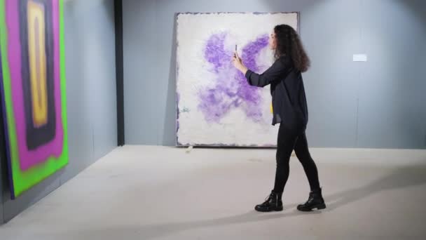 Menina com celular tirar fotos na galeria de arte — Vídeo de Stock