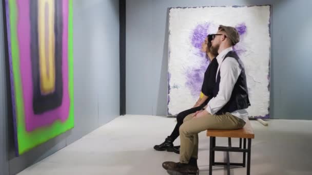 Visitantes de galería de arte mirando la pintura abstracta — Vídeos de Stock