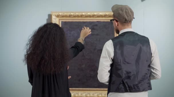 Látogatók a galériában festményekről beszélnek — Stock videók