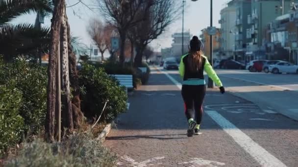Menina em fones de ouvido andando na rua de Rimini, Itália — Vídeo de Stock