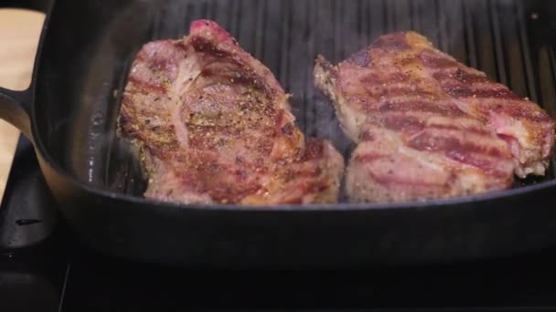 Vleessteaks bereid met specerijen in grillpan — Stockvideo