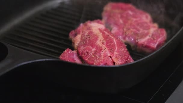 Zwei Fleischstücke in der Pfanne in der heimischen Küche — Stockvideo