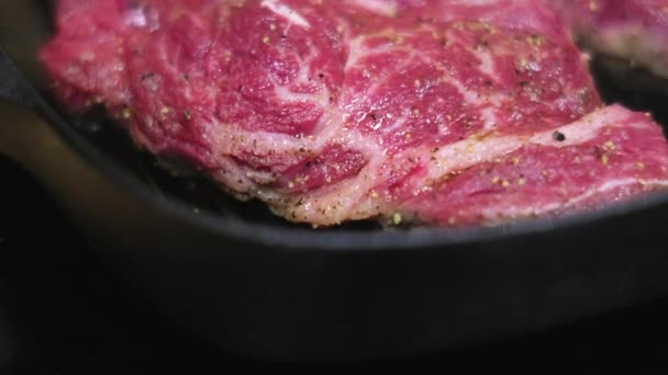 Приготовление говяжьего стейка на сковородке, крупный план — стоковое видео
