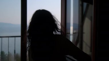 Kadın balkonda müziğin ve sıcak günün tadını çıkaracak.