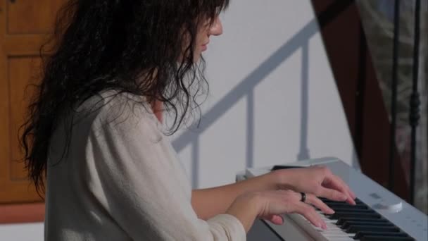 Домашнее развлечение, женщина играет музыку на электронном пианино — стоковое видео