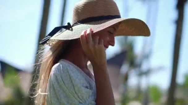Glada kvinna i sol hatt promenader utomhus — Stockvideo
