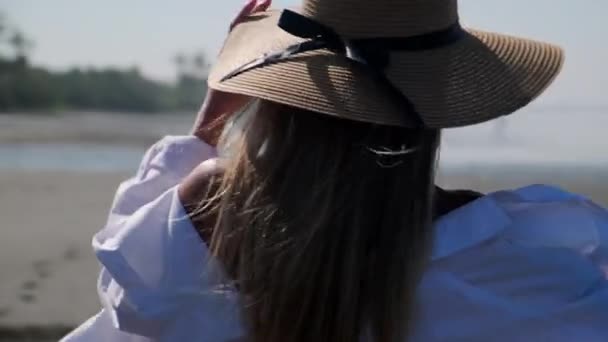 Flicka i sommar hatt promenader på stranden — Stockvideo