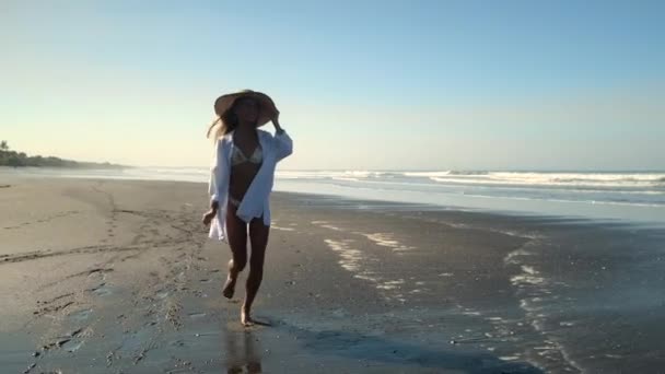 Vacker ung flicka som springer längs havskusten — Stockvideo