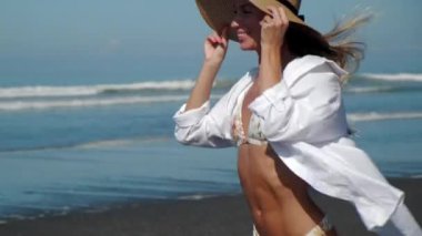 Mutlu kadın okyanus kıyısında koşuyor.