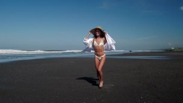 비키니를 입은 여자가 모래사장에서 달리고 있다 — 비디오