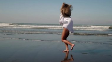 Deniz sahilinde koşan kadın.