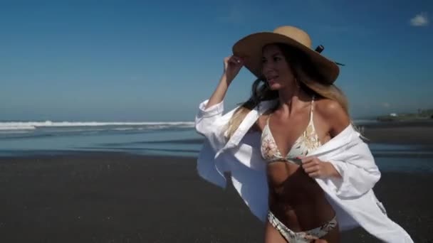 Sexy dama en bikini y sombrero corriendo en la playa — Vídeo de stock