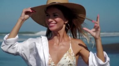 Rüzgarlı okyanus sahillerinde koşan neşeli genç kız.