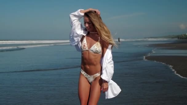 비키니를 입고 해변에서 흰색 셔츠를 입은 아주 섹시 한 여자 — 비디오