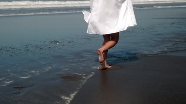 Bezstarostná dívka těší svobodu a běh podél pobřeží oceánu