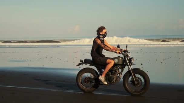 Hombre está conduciendo motocicleta sobre la playa de arena del océano — Vídeos de Stock