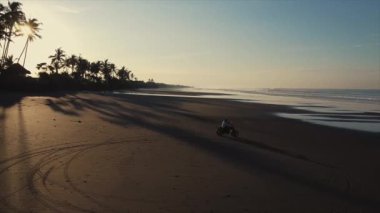 Gün batımında motorcularla okyanus sahilinde uçmak.