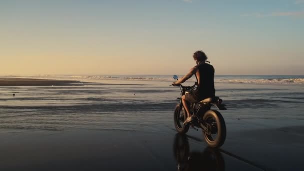 Hombre está conduciendo scooter en la playa de arena del océano — Vídeos de Stock