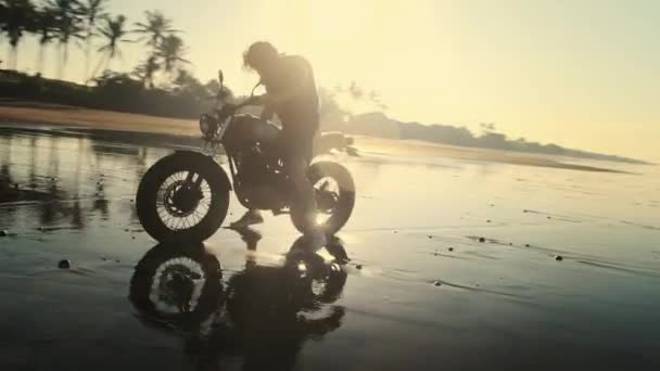 Homem chutando bicicleta leve na praia do oceano — Vídeo de Stock