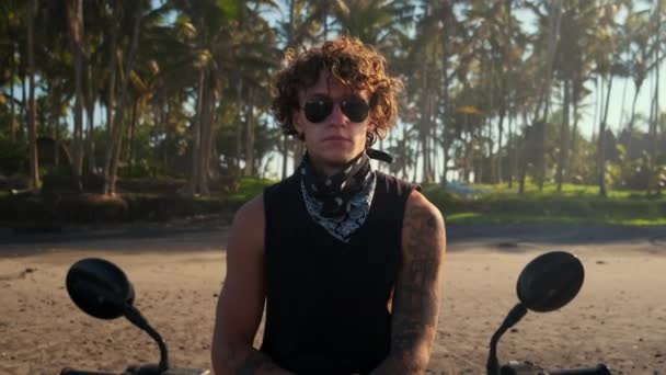 Brutální motorkář portrét na tropické pláži — Stock video