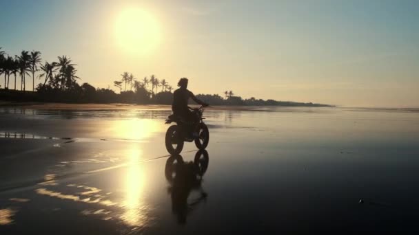 Байкер на мотоцикле в сумерках вдоль океана — стоковое видео