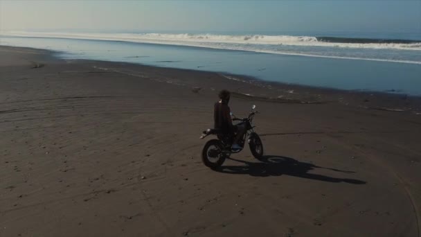 Cansado motociclista tendo descanso em uma praia do oceano à noite — Vídeo de Stock