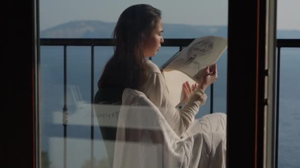 Artiste féminine esquissant sur le balcon avec vue panoramique sur la mer — Video