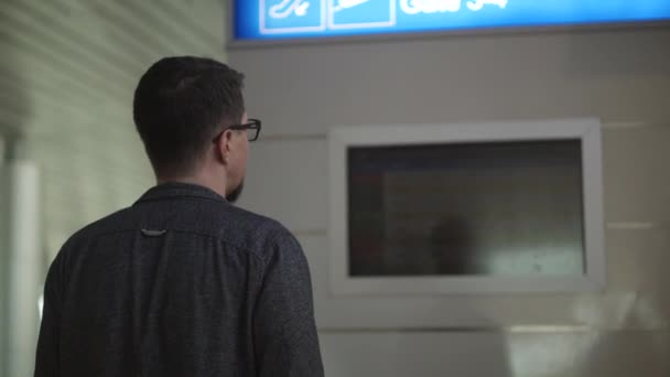 Passager visualise le panneau d'information à l'aéroport — Video