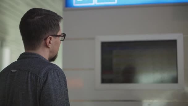 Концентрований турист шукає інформацію про свій рейс в аеропорту — стокове відео