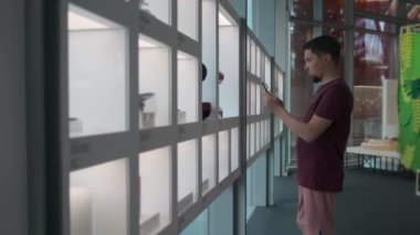 Adam müzenin içinde akıllı telefonla fotoğraf çekiyor.