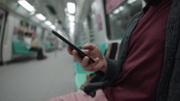 Metro yolculuğu sırasında cep telefonundan haberler kontrol ediliyor. — Stok video