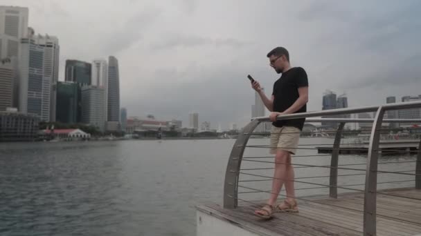Man menggunakan mobile oleh Marina Bay di Singapura — Stok Video