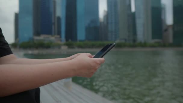 Mens typt in smartphone in de stad — Stockvideo