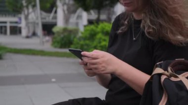 Kadın şehir dışında akıllı telefon kullanıyor.