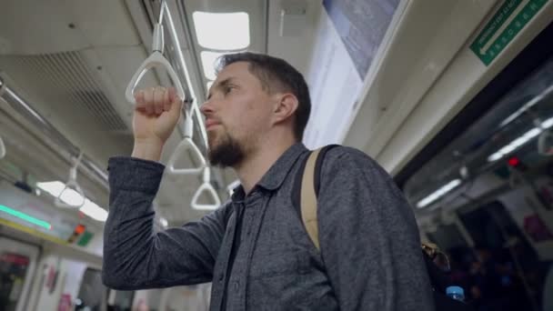 Sichere U-Bahn-Fahrt. Mann hält Haltestreifen im Zug — Stockvideo