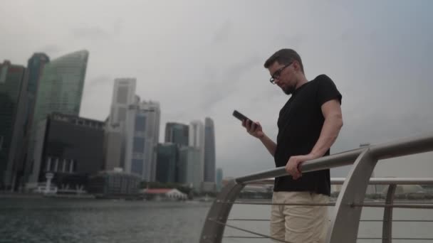 Concentrated man using a smartphone on the magnificent river embankment