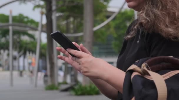 Mulher mãos usando smartphone em uma moderna rua turística da cidade — Vídeo de Stock