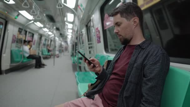 Homem usando smartphone no trem do metrô — Vídeo de Stock