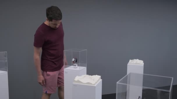 Hombre examinando objetos de exhibición en la exposición de la tecnología moderna — Vídeo de stock