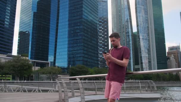 Seorang pria dengan ponsel di pusat kota Singapura — Stok Video