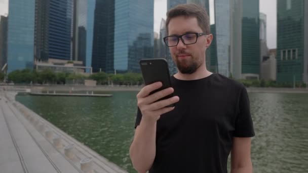 Hombre con teléfono celular en la gran ciudad, enviando mensaje — Vídeo de stock