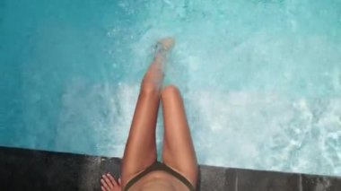 Yaz sıcağında serinlemek için yüzme havuzunda sallanan kız.