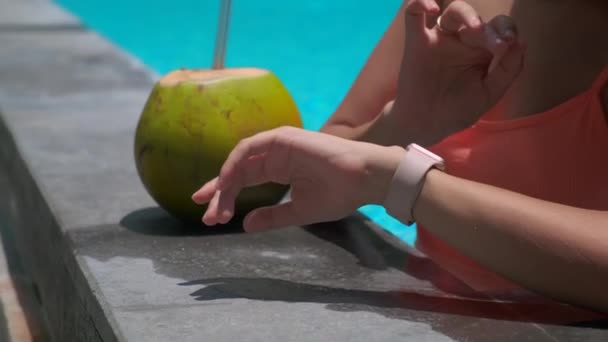 Vrouwelijke toerist controleert smartwatch in zwembad — Stockvideo