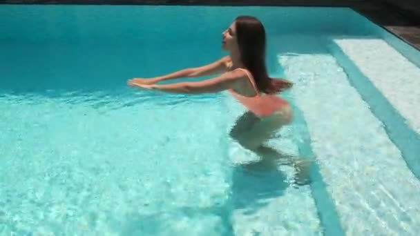 Κορίτσι χαλαρωτικό και κολύμπι σε καθαρά νερά της πισίνας — Αρχείο Βίντεο