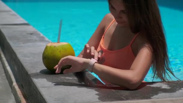 Slim actieve meisje met behulp van smartwatch in open zwembad — Stockvideo