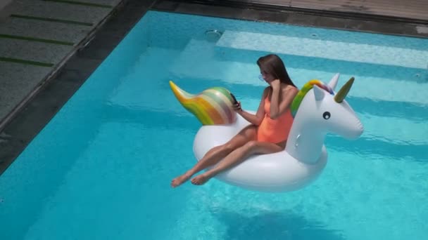 Mulher bonita nadando em uma piscina em um brinquedo inflável — Vídeo de Stock